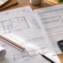 Architectural drawings and a cost plan printout with a scale rule and calculator
